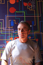 Portrait photographique de Thierry Hersant devant un plan de circuit électrique